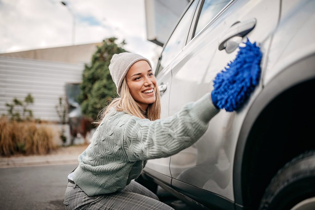 woman softly cleaning vehicle with wrap
